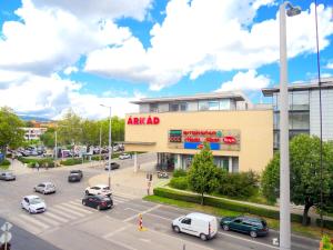 una vista de un centro comercial con coches aparcados en un aparcamiento en Árkád Apartman-Pécs, en Pécs