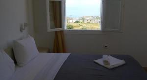 1 dormitorio con 1 cama blanca y ventana en fira blue horizon, en Fira