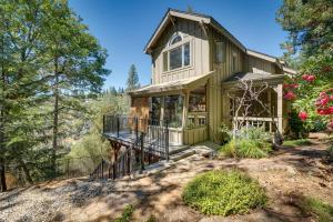 a green house with a porch and a balcony at Meadow Vista Mountain Escape with River Views! 