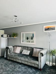 ein Wohnzimmer mit einem grauen Sofa in einem Zimmer in der Unterkunft The Annex in Southend-on-Sea