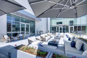 an outdoor patio with couches and tables and an umbrella at Hilton Garden Inn Denver Union Station in Denver