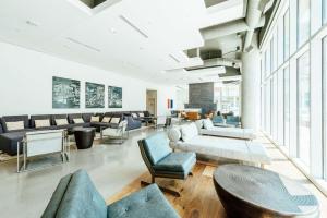 a living room with couches and tables and windows at Hilton Garden Inn Denver Union Station in Denver