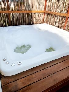 a white bath tub sitting on top of a wooden cabinet at Alameda Lounge Pousada in Pôrto de Pedras