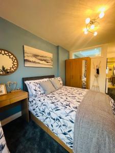Schlafzimmer mit einem Bett, einem Tisch und einem Spiegel in der Unterkunft The Annex in Southend-on-Sea