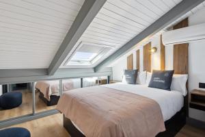 a bedroom with a bed and a vaulted ceiling at Limehome Madrid Calle de Santa Ana - estancia temporal in Madrid