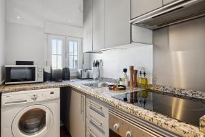 a kitchen with a washing machine and a microwave at Limehome Madrid Calle de Santa Ana - estancia temporal in Madrid +43 photos