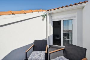 two chairs on a balcony with a window at Limehome Madrid Calle de Santa Ana - estancia temporal in Madrid