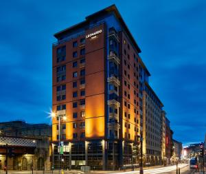 ein hohes Gebäude in der Nacht auf einer Stadtstraße in der Unterkunft Leonardo Royal Hotel Glasgow in Glasgow