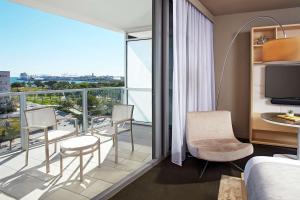 a hotel room with a balcony with a bed and chairs at The Gabriel Miami Downtown, Curio Collection by Hilton in Miami