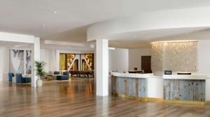 洛杉矶Hilton Los Angeles-Culver City, CA的大堂设有前台台和蓝色椅子 更多37张照片