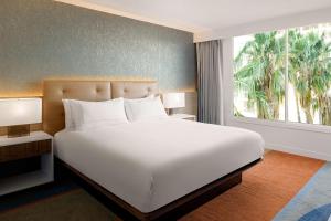 洛杉矶Hilton Los Angeles-Culver City, CA的卧室里有一张白色的大床和一扇窗户