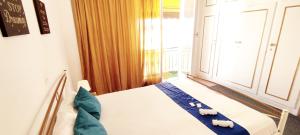 雅典的住宿－Cozy room in quiet neighbourhood，一间卧室配有一张带蓝色床单的床和一扇窗户。