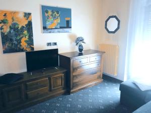 a room with a wooden dresser with a television on it at Hotel Parco Fiera in Turin