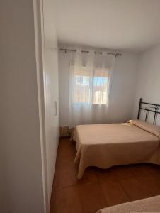 een kleine slaapkamer met 2 bedden en een raam bij Villa Lago Mayor in Chiclana de la Frontera