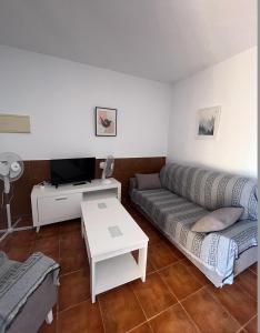 een woonkamer met een bank en een tafel bij Villa Lago Mayor in Chiclana de la Frontera