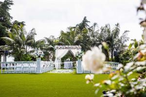 een trouwgang met witte stoelen en een tent bij Cape Rey Carlsbad Beach, A Hilton Resort & Spa in Carlsbad