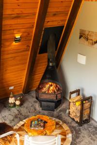 a wood fired oven in a room with a table at Cabana com Hidromassagem e Vista, a 12km de Treze Tílias in Ibicaré