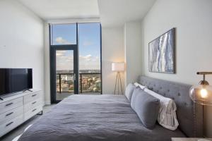 ein Schlafzimmer mit einem großen Bett und einem Fernseher in der Unterkunft Luxury 2bdrm Penthouse in Midtown in Atlanta