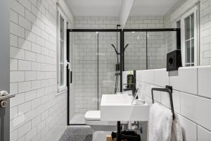 uma casa de banho branca com um lavatório e um espelho em limehome Madrid Calle de Santa Ana em Madri