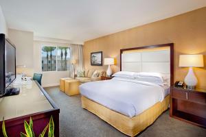卡尔斯巴德Cape Rey Carlsbad Beach, A Hilton Resort & Spa的配有一张大床和一张书桌的酒店房间