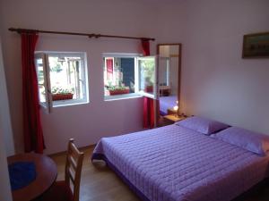 a bedroom with a bed and two windows at House Ilija Hodak in Seliste Dreznicko