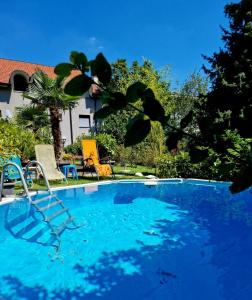 a swimming pool with chairs and a house at Victoria Royal Garden in Como