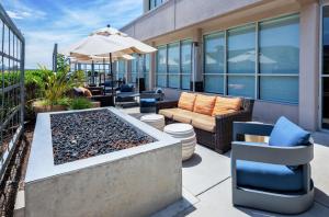 eine Terrasse mit einem Tisch, Stühlen und einem Sonnenschirm in der Unterkunft Hilton Garden Inn San Francisco/Oakland Bay Bridge in Emeryville