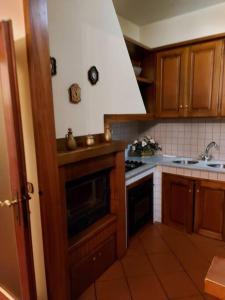 een keuken met houten kasten en een fornuis met oven bij Villa Debora in Lucca