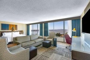 a hotel room with a king bed and a living room at Hilton Garden Inn San Francisco/Oakland Bay Bridge in Emeryville