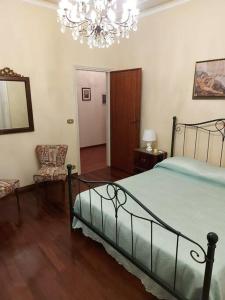 een slaapkamer met een bed en een kroonluchter bij Villa Debora in Lucca