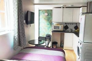 a small kitchen with a table and a microwave at Quiet and cozy studio in Hendon
