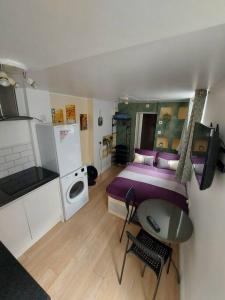 a bedroom with a bed and a table and a kitchen at Quiet and cozy studio in Hendon