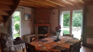 a dining room with a table and a fireplace at Les FEICHES et MARGUERITES in Ignaux