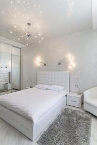 a white bedroom with a large white bed and a couch at Minsklux Apartment 2 in Minsk