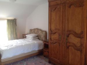 una camera da letto con un grande armadio in legno accanto a un letto di Freval 