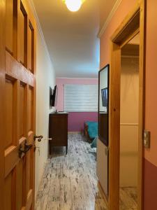 un pasillo con una habitación con paredes rosas y una puerta en Habitaciones en Casa Familiar, en Puerto Montt