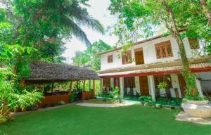 a house with a green yard in front of it at Dambulla Kings Inn in Dambulla