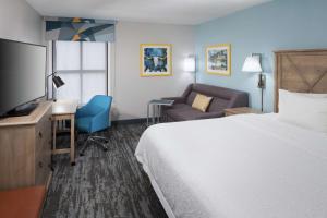a hotel room with a bed and a desk and a chair at Hampton Inn Austin Round Rock in Round Rock