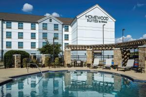 a hotel with a pool in front of a building at Homewood Suites by Hilton Austin/Round Rock in Round Rock