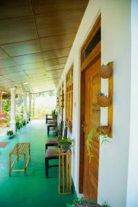 Dambulla Kings Inn في دامبولا: شرفة مع صف من الكراسي والنباتات