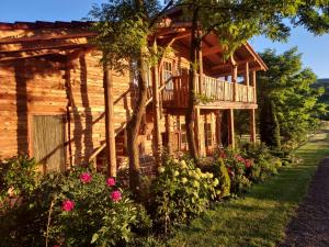 Cabaña de madera con terraza y flores en Country Chalet, en Praid