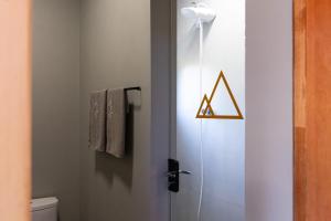 a bathroom with a shower door with a triangle sign on it at Cabana com Hidromassagem e Vista, a 12km de Treze Tílias in Ibicaré