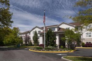a white building with an american flag in front of it at Homewood Suites by Hilton Newark-Cranford in Cranford