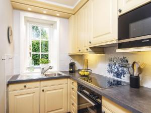 a kitchen with white cabinets and a sink and a window at Hansenhoog-2 in Kampen