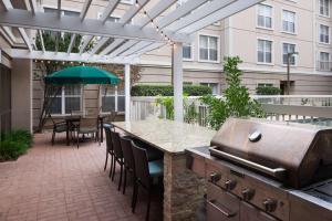 um pátio com comodidades para churrascos, uma mesa e cadeiras em Homewood Suites by Hilton Austin NW near The Domain em Austin