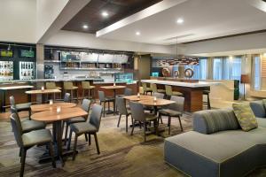 un restaurante con mesas y sillas y un bar en Courtyard Charlotte SouthPark, en Charlotte