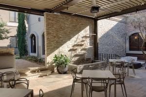 a patio with tables and chairs and a brick wall at Hilton Garden Inn Las Colinas in Irving