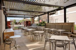 a restaurant with tables and chairs in a patio at Hilton Garden Inn Las Colinas in Irving