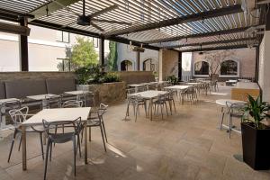 eine leere Terrasse mit Tischen und Stühlen in einem Gebäude in der Unterkunft Hilton Garden Inn Las Colinas in Irving