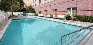 a large blue swimming pool with chairs and a building at Embassy Suites by Hilton Destin Miramar Beach in Destin